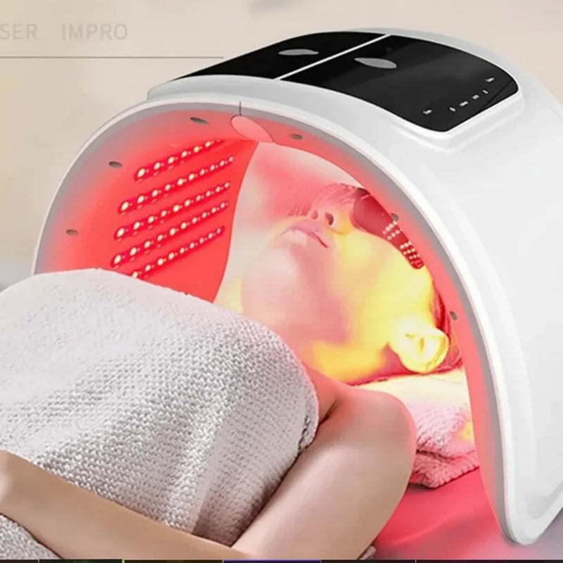 Woman receiving LED red light therapy under dome-shaped skincare device