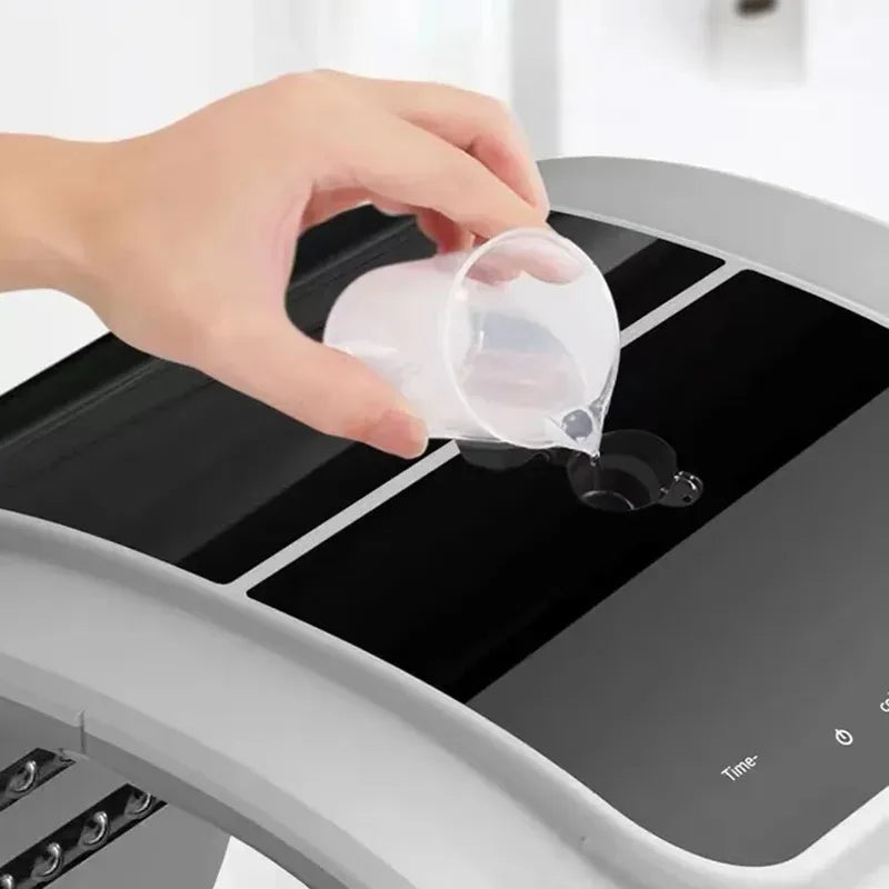 Hand pouring water into a black automatic facial steamer machine panel